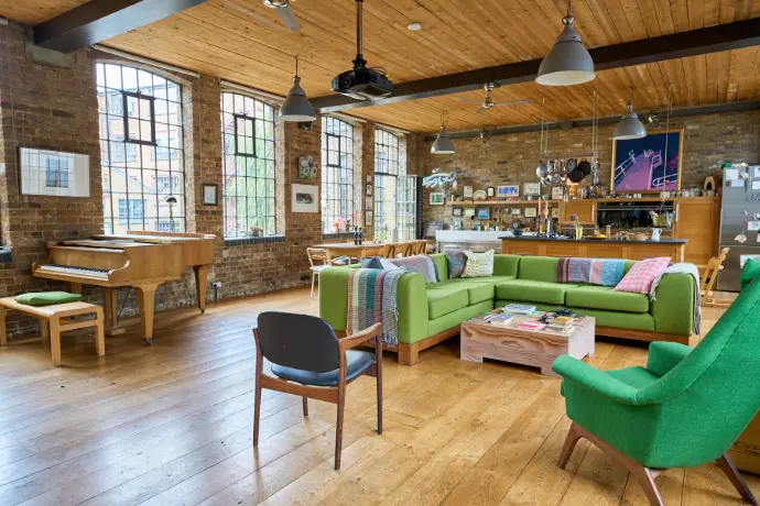 Interior view of a modern, rustic office space with large windows and wooden floors